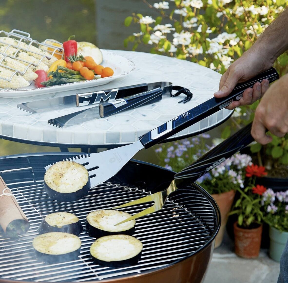 Man grilling, holding grilling utensils