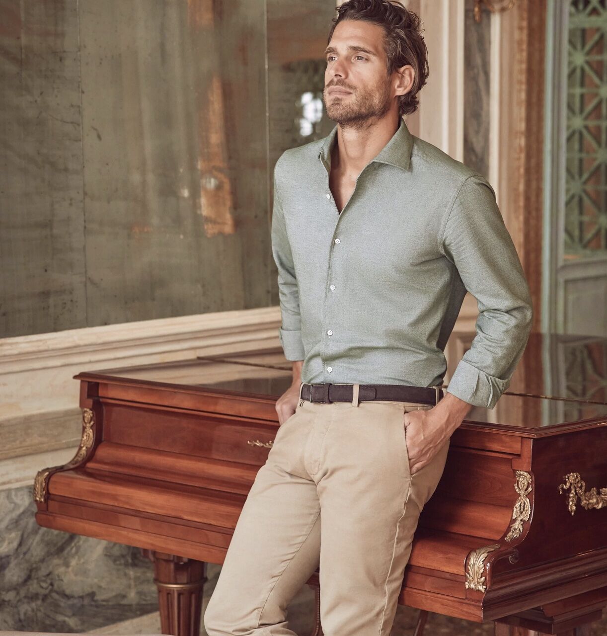 man leaning against a piano